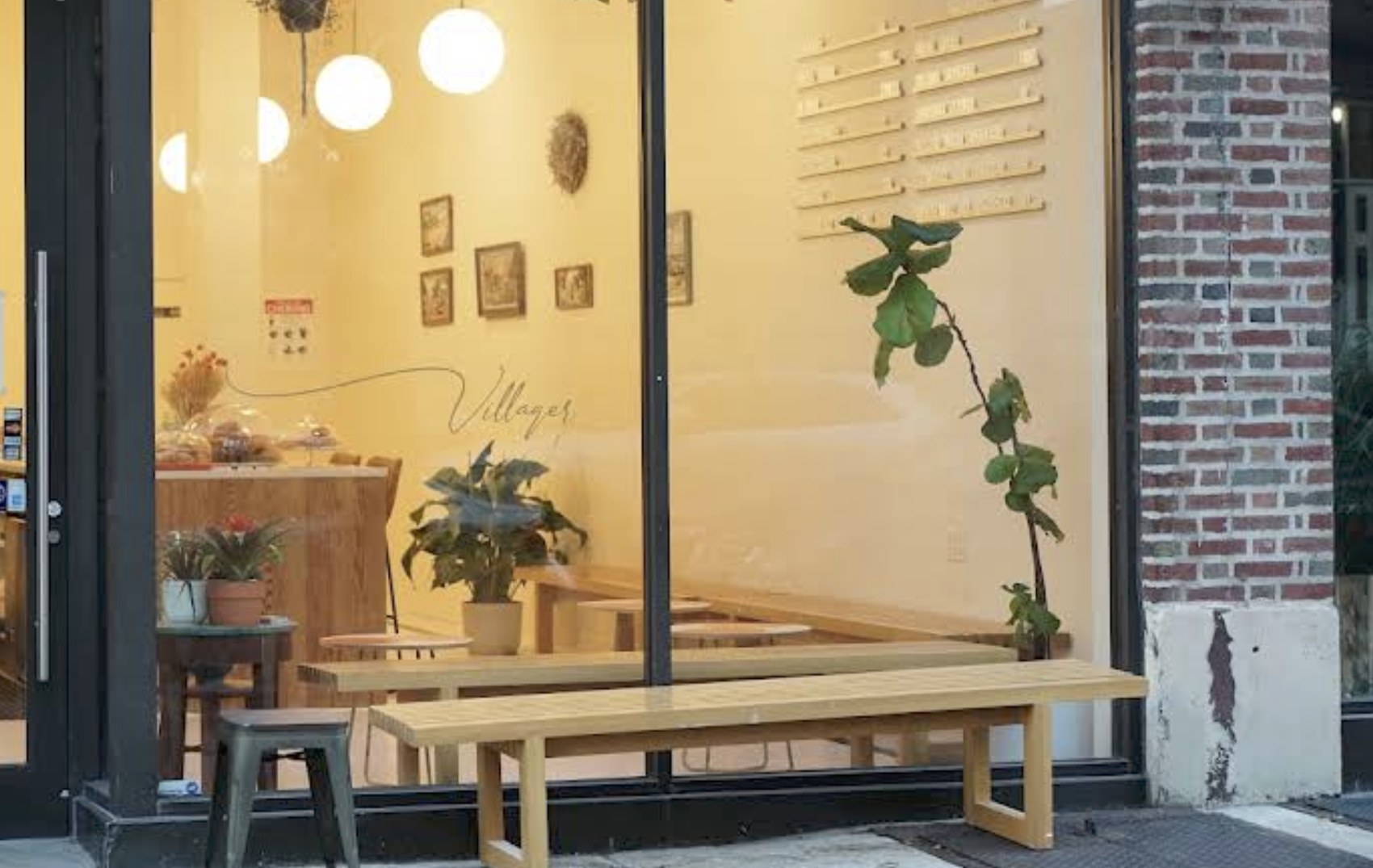 The Villager storefront window with the wordmark and bench seating visible inside